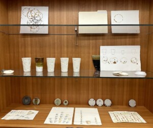 Ceramic coffee cups and other ephermera on a shelf