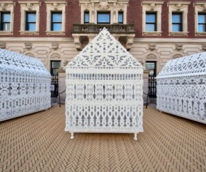 A detail photograph of La Vaughn Belle's, "The House That Freedoms Built." Made up of three ornate, white scupltures that resemble three homes.