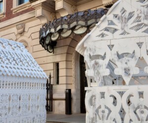 A detail photograph of La Vaughn Belle's, "The House That Freedoms Built." Made up of three ornate, white scupltures that resemble three homes.